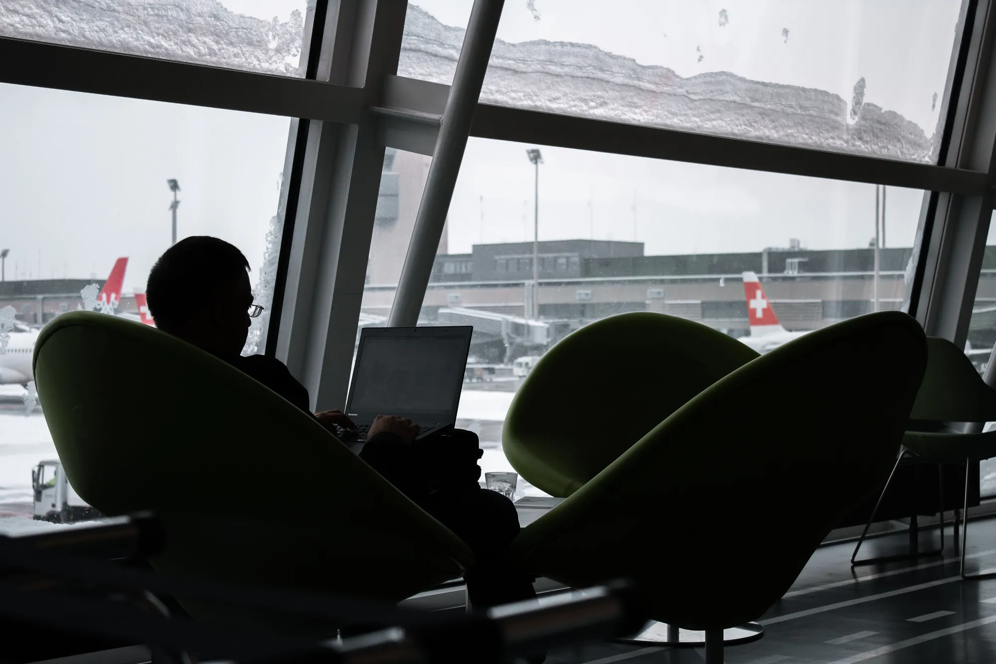 Business traveler working on a laptop in an airport departure lounge