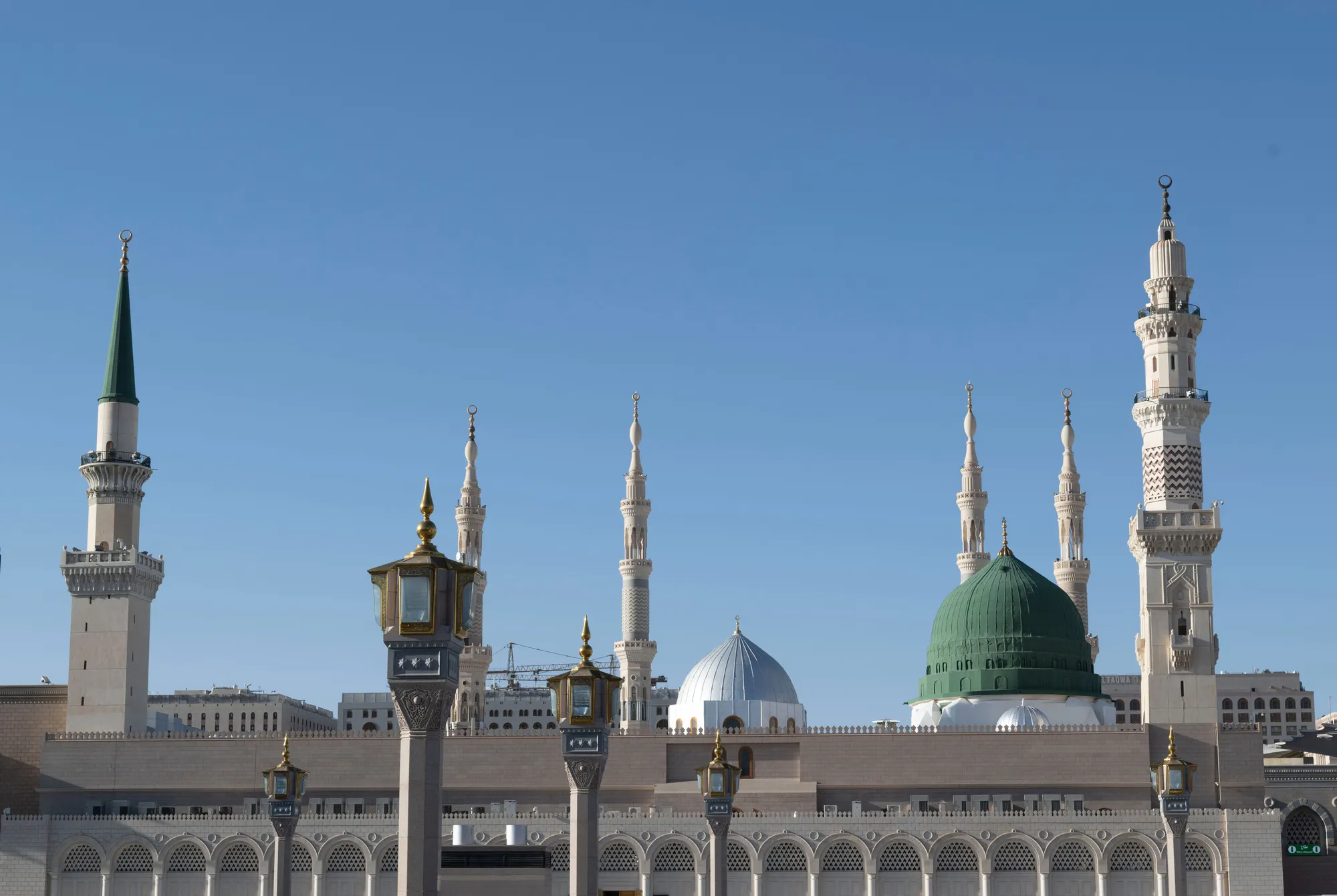 Al-Masjid an-Nabawi's green dome and minarets against a clear sky, Madinah